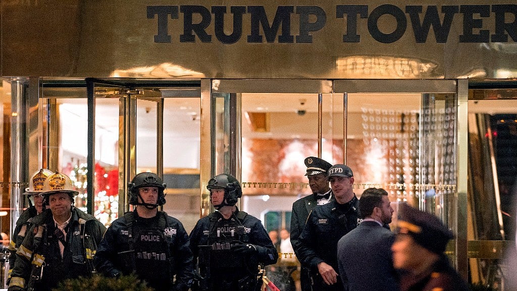 

New York firefighters, police officers and others stand outside Trump Tower lobby in New York, Tuesday, 27 December 2016. (Photo: AP)
