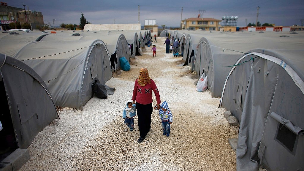 A Kurdish refugee woman, from the Syrian town of Kobanî, walks with her children at a refugee camp in the border town of Suruç, Şanliurfa province. (Photo: Reuters)
