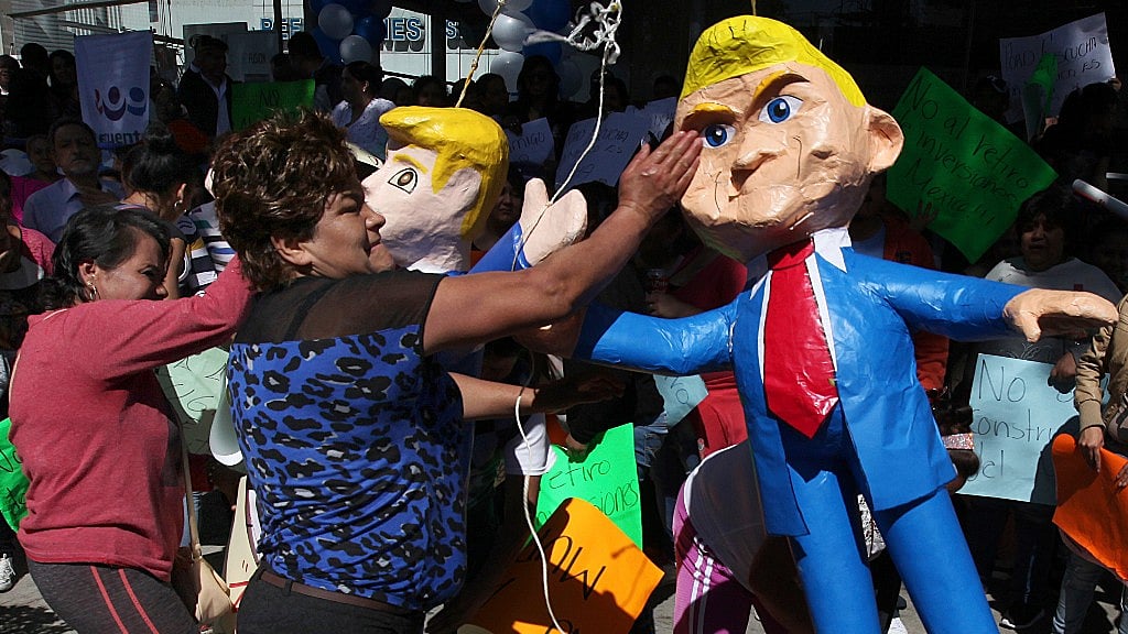 

Women smack pinatas at the likeness of US President Donald Trump in Mexico City,  20 January 2017. (Photo: AP)