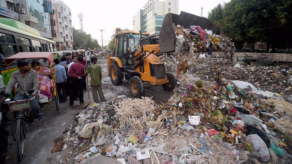 MCD workers cleaning up the garbage. (Photo: PTI)