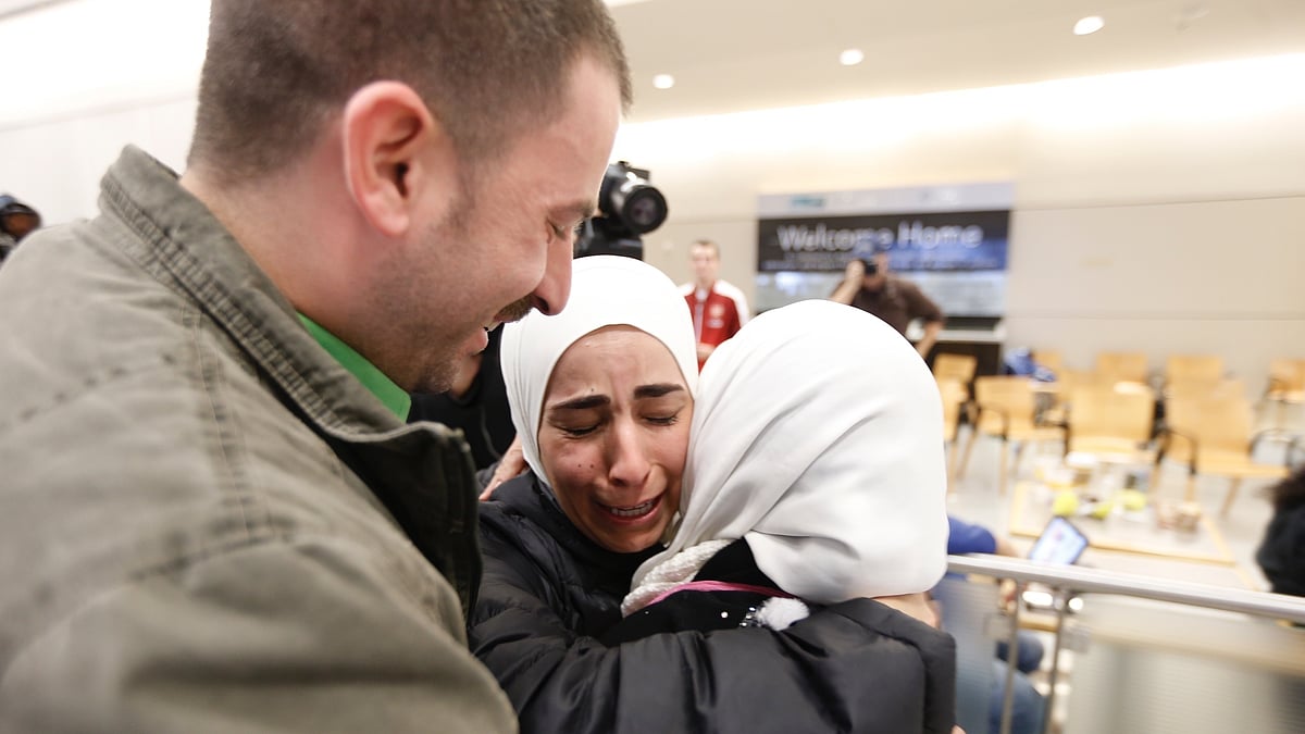 Hisham (left) and Mariam Yasin (center) welcome their mother Najah Alshamieh from Syria after immigration authorities released her at Dallas Fort Worth Airport on January 28 2017. (Photo: AP)