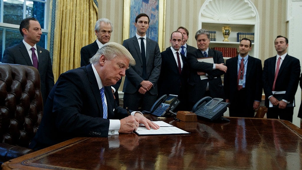 President Donald Trump signs an executive order implementing a federal government hiring freeze, on Monday. (Photo: AP)