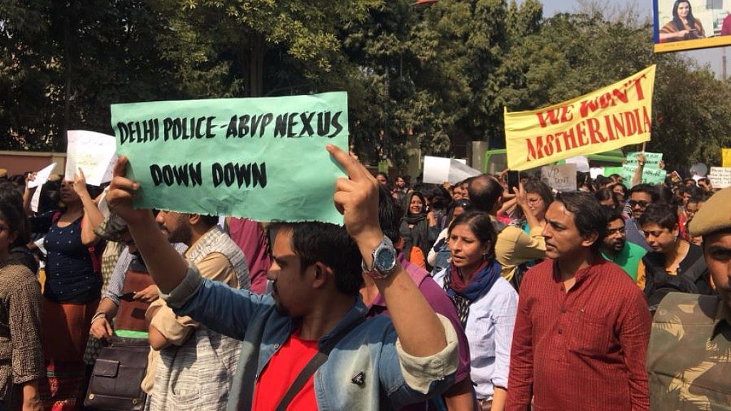 Protesters hold placards outside SGTB Khalsa college on Tuesday. (Photo: <b>The Quint</b>)