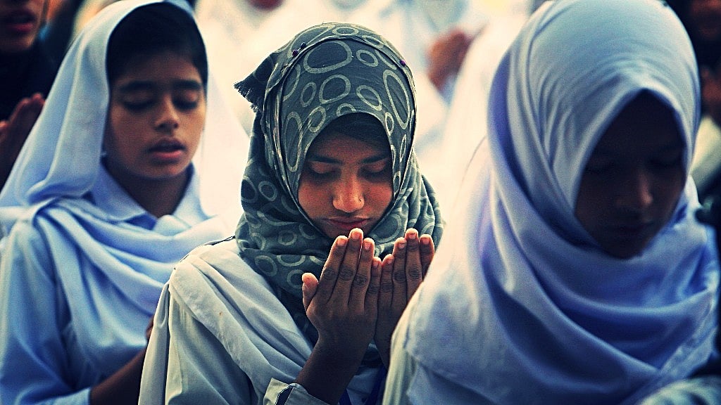 Pakistani students pray for victims of suicide bombing at the Lal Shahbaz Qalandar shrine on 17 February 2017 in Karachi, Pakistan. (Photo: AP/ Altered by <b>The Quint</b>)