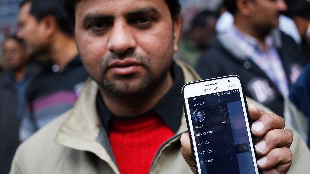 An Uber taxi driver shows the application software on his mobile phone.&nbsp;