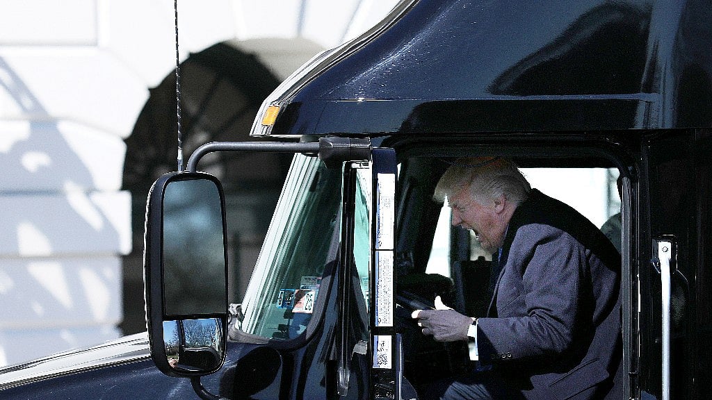 US President Donald Trump got into a parked truck and pretended to drive, in a gesture to welcome trucking industry representatives to the White House. (Photo: Reuters)
