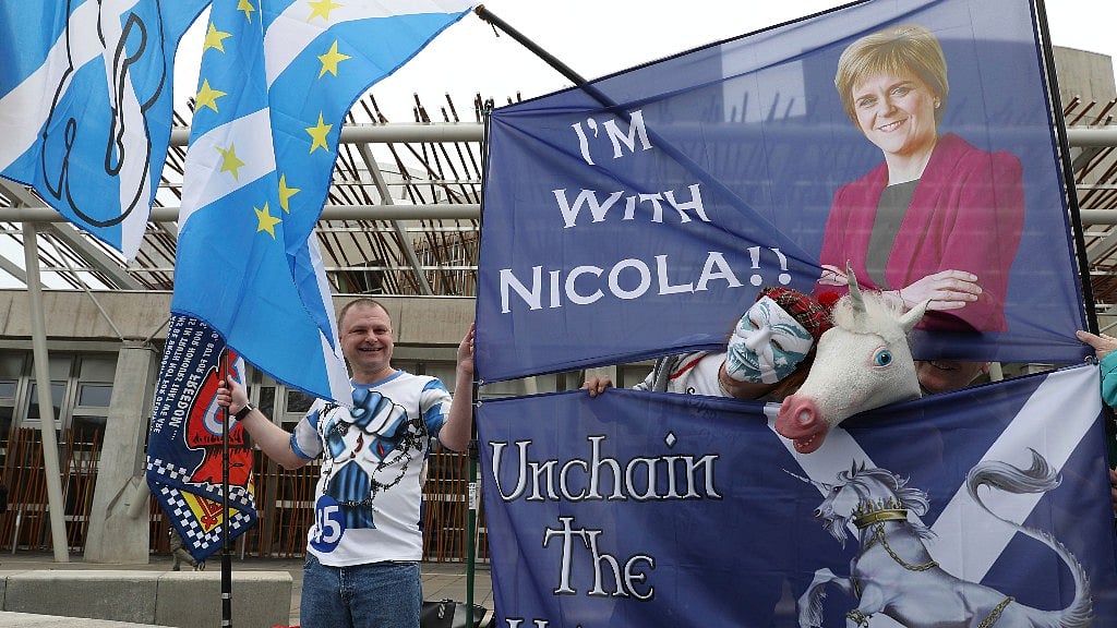 Scottish Independence supporters hold flags and banners outside the Scottish Parliament in Edinburgh on Tuesday. (Photo Courtesy: AP)