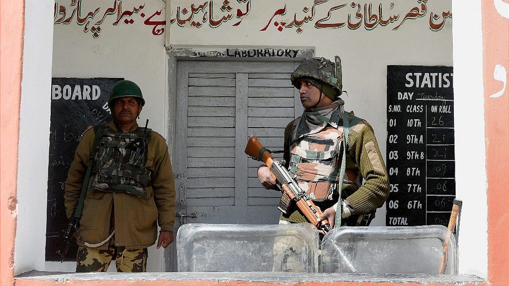 Jawans stand guard outside a polling station for Srinagar Lok Sabha seat in Budgam on Sunday. (Photo: PTI)