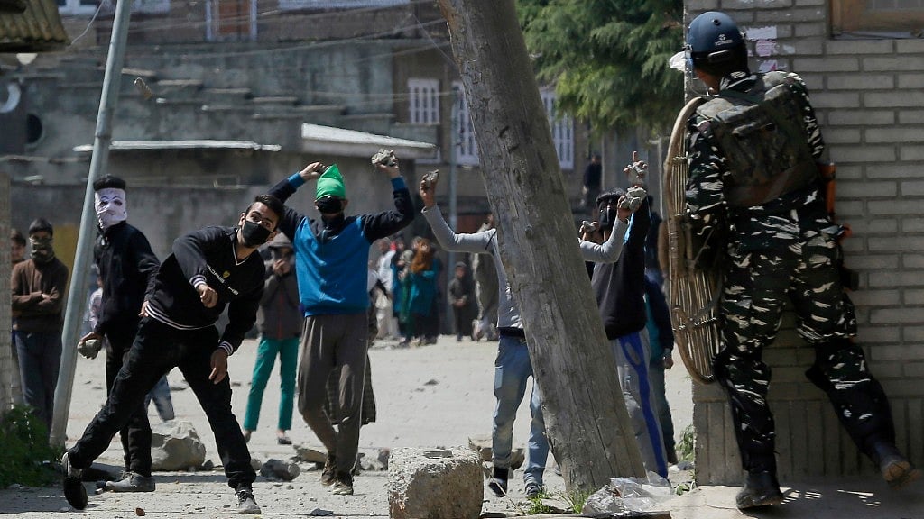 Kashmiri protesters throw stones on Indian security men outside a poling station during a by-election to an Indian Parliament seat in Srinagar, Kashmir. 