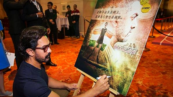 Aamir Khan autographs a Chinese poster of <i>Dangal. </i>(Photo courtesy: Pinterest) 