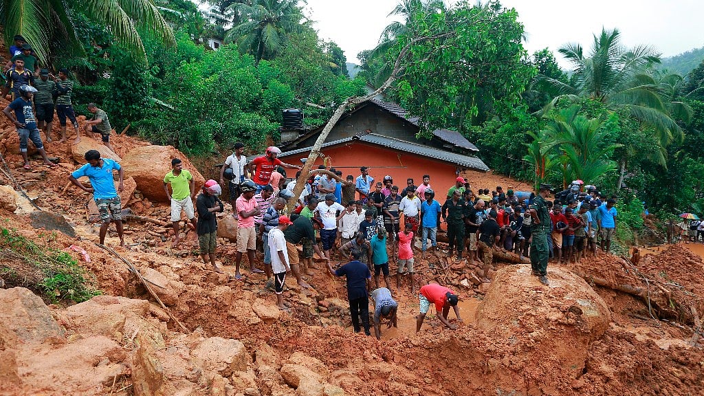 Sri Lankans watch military rescue efforts at the site of a landslide in Bellana village in Kalutara district, Sri Lanka, Friday, 26 May 2017. (Photo: AP)