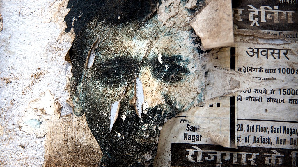 A torn poster of Delhi Chief Minister Arvind Kejriwal on the wall of a residential colony in New Delhi. (Photo: AP)