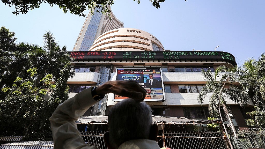 A man looks at a screen across the road displaying the Sensex on the facade of the Bombay Stock Exchange (BSE) building in Mumbai.&nbsp;