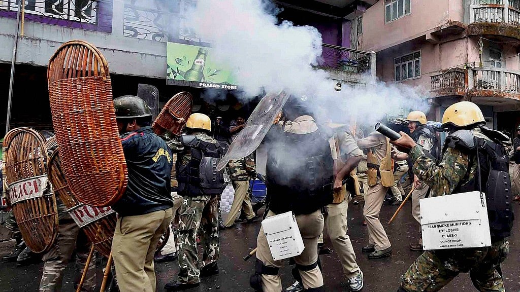 Security personnel fire tear gas during a protest by Gorkha Janmukti Morcha (GJM) activists in Darjeeling on Saturday (Photo: PTI)