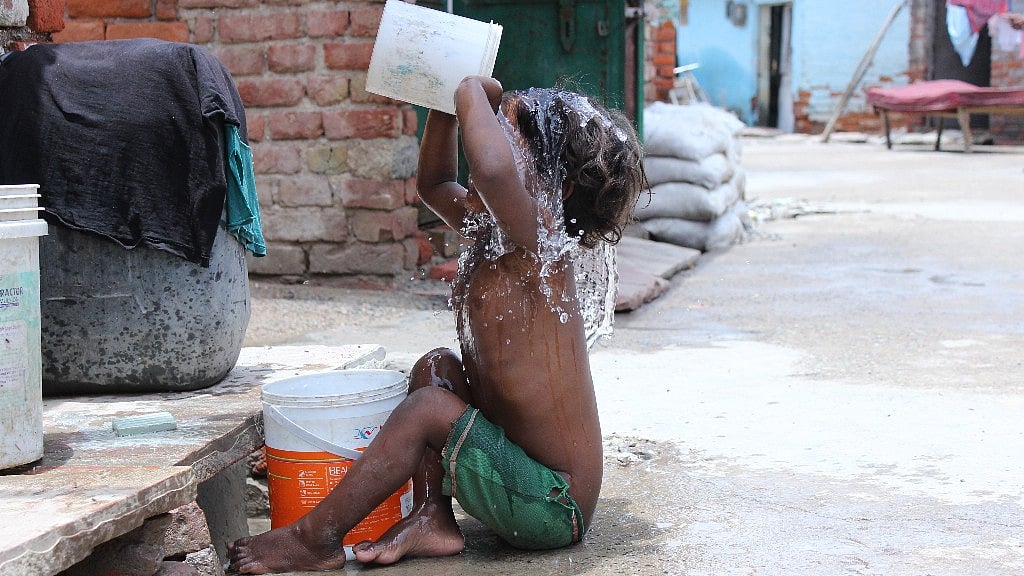 A child bathes in Shahbad Dairy, Western Delhi. (Photo: Shorbori Purkayastha/<b>The Quint</b>)