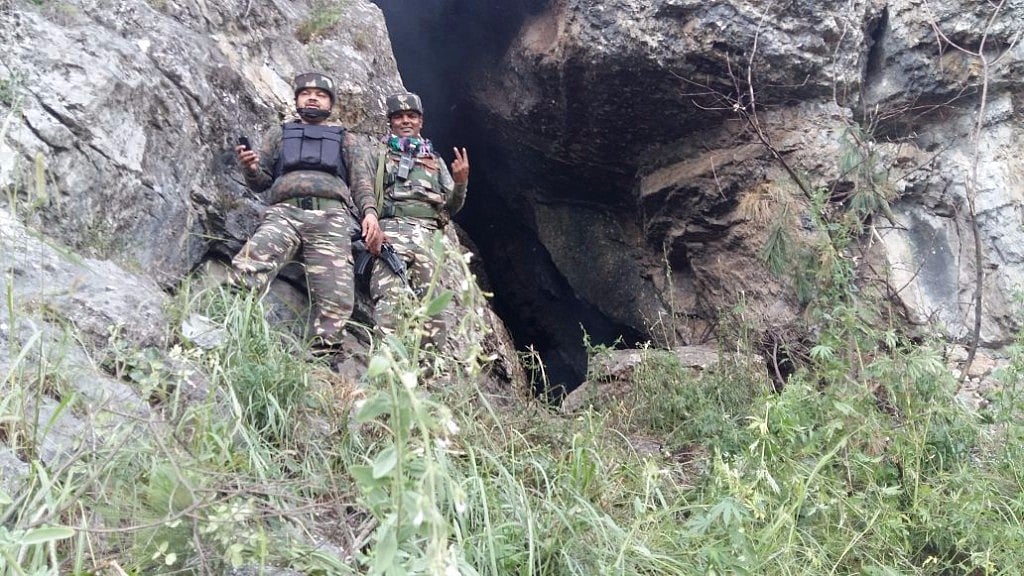 Security forces in front of the cave where the militants were reported to be hiding in a forest in Tral in Pulwama district of south Kashmir.