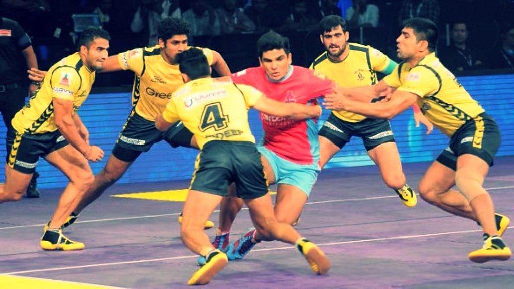 The Telugu Titans players attempt to tackle a Jaipur Pink Panthers raider during the fourth season of the Pro Kabaddi League.