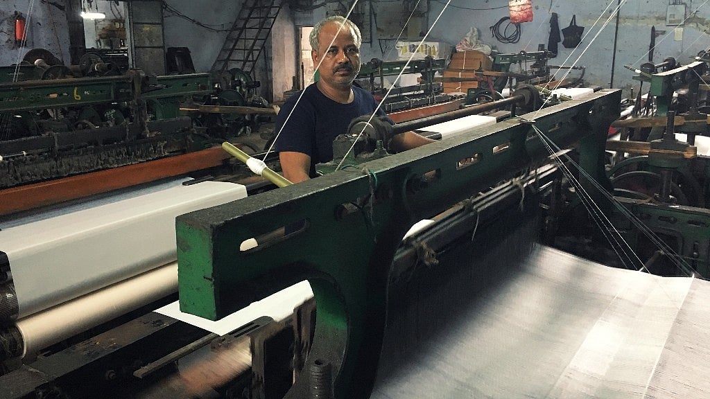 A mill worker wrapping up work on his last day at a soon-to-be-shut power loom in Bhiwandi.