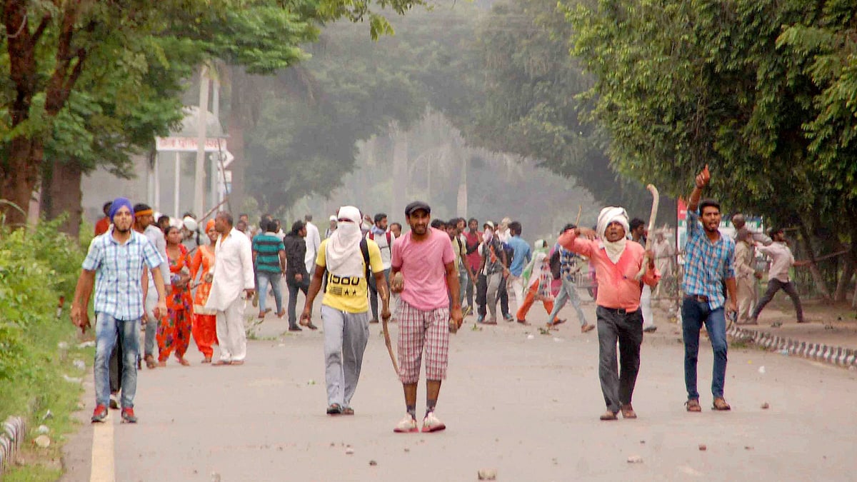 Supporters of Dera Sacha Sauda chief Gurmeet Ram Rahim pelting stones as security personnel in violence following court verdict in the rape trial of Dera Sacha Sauda chief Gurmeet Ram Rahim, in Panchkula on 25 August.