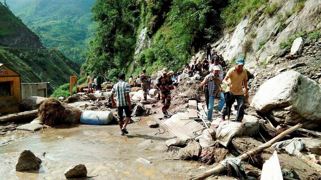 People walk towards a Kailash Mansarovar road after a cloud burst at Pithoragarh district in Uttarakhand.