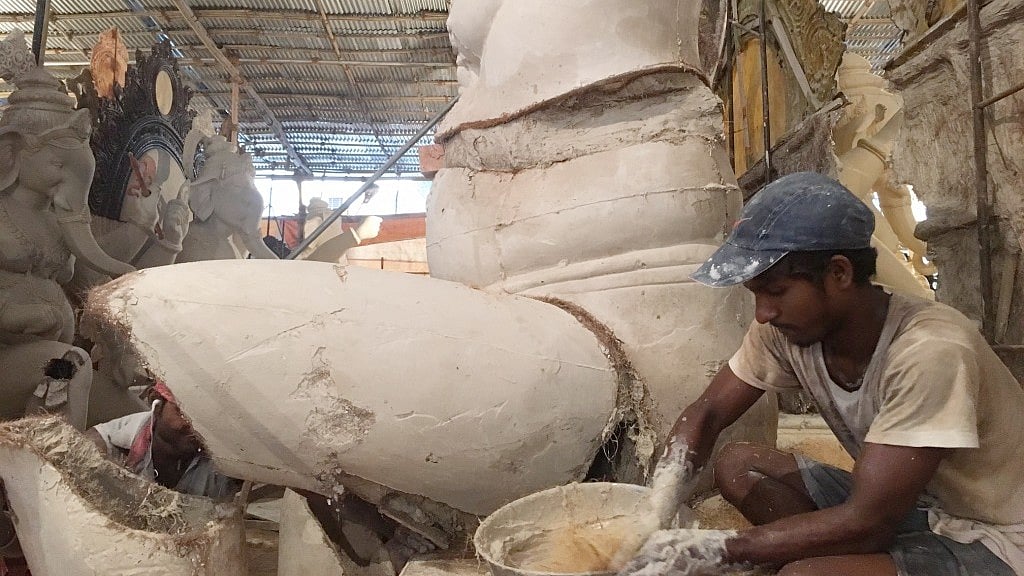 An idol-maker moulds a Ganesh idol at a workshop in Parel.