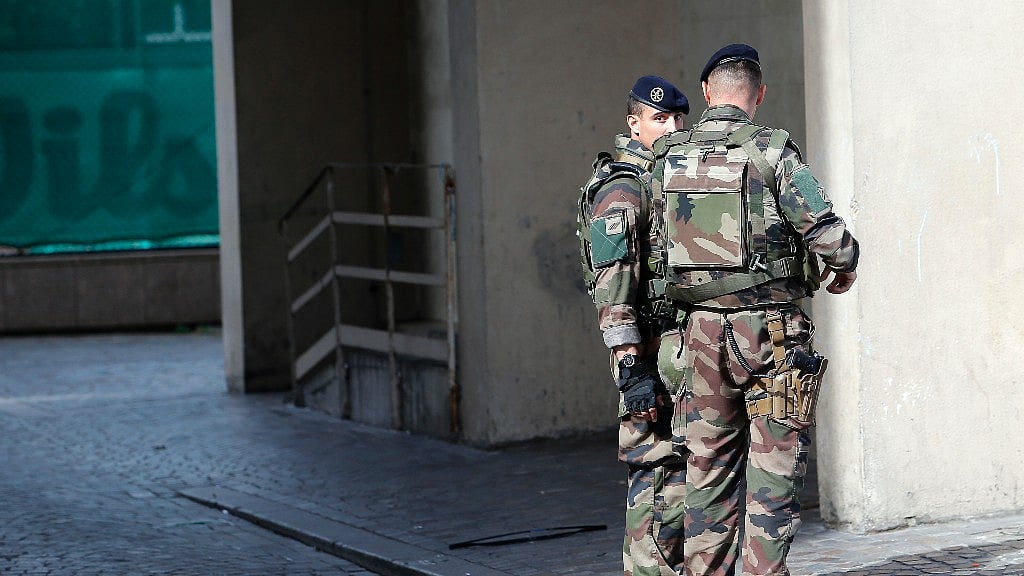 Two soldiers stand at the site of accident. 