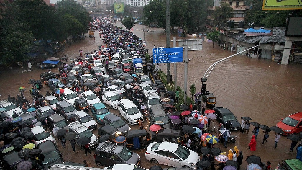 Vehicles stuck at a flooded street after heavy rains in Thane, Mumbai on Tuesday.