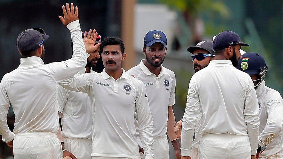Ravindra Jadeja celebrates a wicket with his teammates.