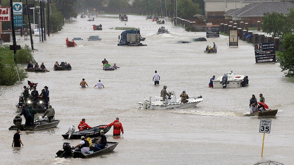 People and rescue boats line a street at the east Sam Houston Tollway as rescues continue from flooding following Tropical Storm Harvey.