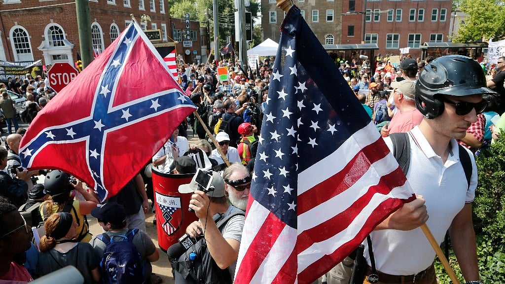 White nationalist demonstrators walk into Lee park surrounded by counter demonstrators in Charlottesville in Virginia on 12 August.