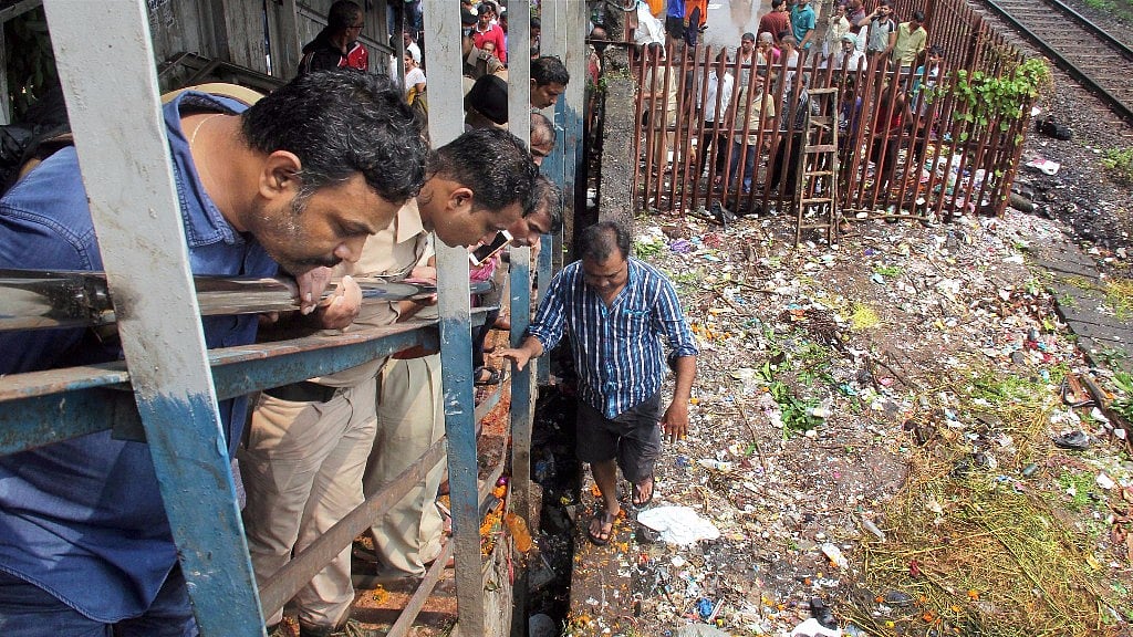 People look on at the site of a stampede that broke out on the Elphinstone Railway Station bridge in Mumbai on Friday.