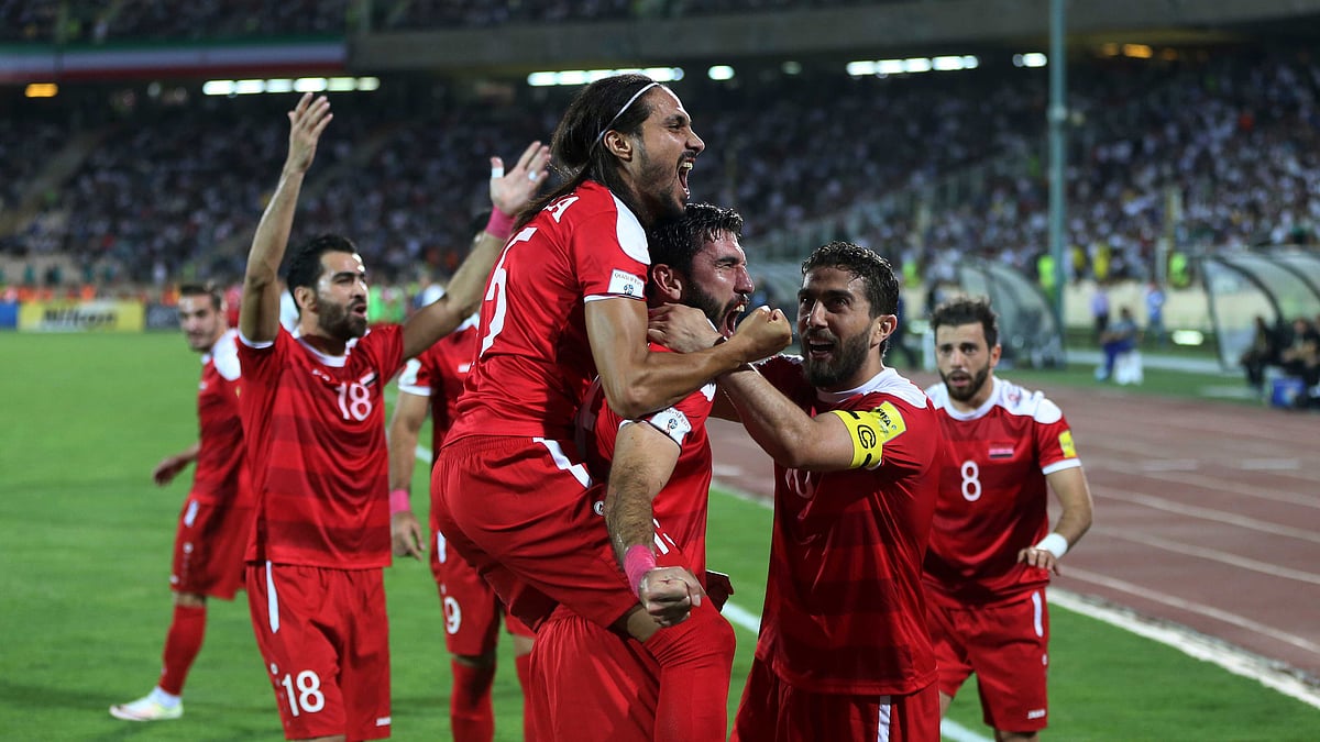 Syria’s soccer team celebrates after scoring a goal against Iran during their Round 3 - Group A World Cup qualifier at the Azadi Stadium in Tehran.