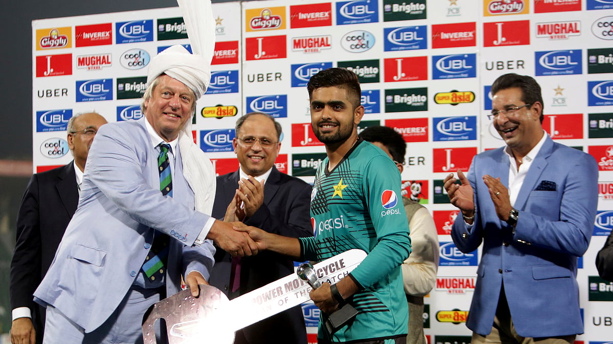 Pakistani cricketer Babar Azam, center, receives man of the match award from Director of the International Cricket Council (ICC) Giles Clarke at the end of the first Twenty20 match between the World XI and Pakistan