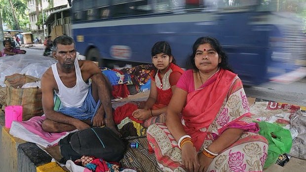 A cancer patient and his wife and daughter sit on the divider under the monorail station near Tata Memorial Hospital, Parel, Mumbai. Unable to afford a hotel or a dharmshala (rest house), many live on the pavements till treatment is complete.
