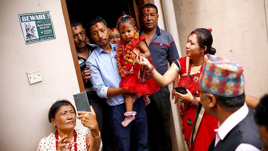 Nepal’s new living goddess Trishna Shakya is carried by her father as they leave home for a temple palace in Kathmandu. 