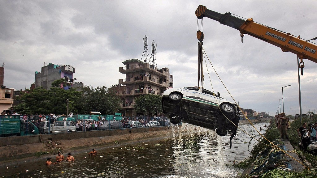 A car being pulled out of a canal as the rescue operations are underway after a part of the Ghazipur garbage landfill collapsed in east Delhi.