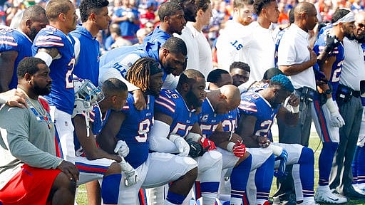 Buffalo Bills players take a knee during the playing of the national anthem prior to an NFL football game against the Denver Broncos on Sunday 24 September 2017, in Orchard Park, New York.