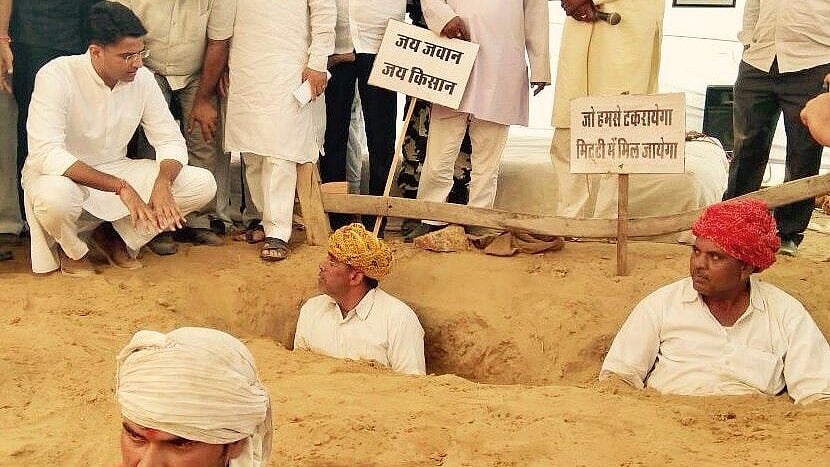 For over a week, farmers in Rajasthan’s Nindar have been protesting neck-deep in soil against the JDA. (Photo Courtesy: <a href="https://twitter.com/SachinPilot">@<b>SachinPilot</b></a>/Twitter)