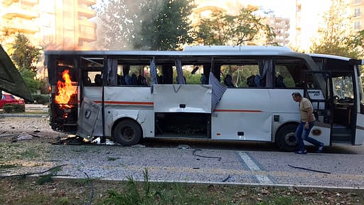 A bus carrying police officers still burning shortly after a bomb went off near it. <i>(Photo: AP)</i>