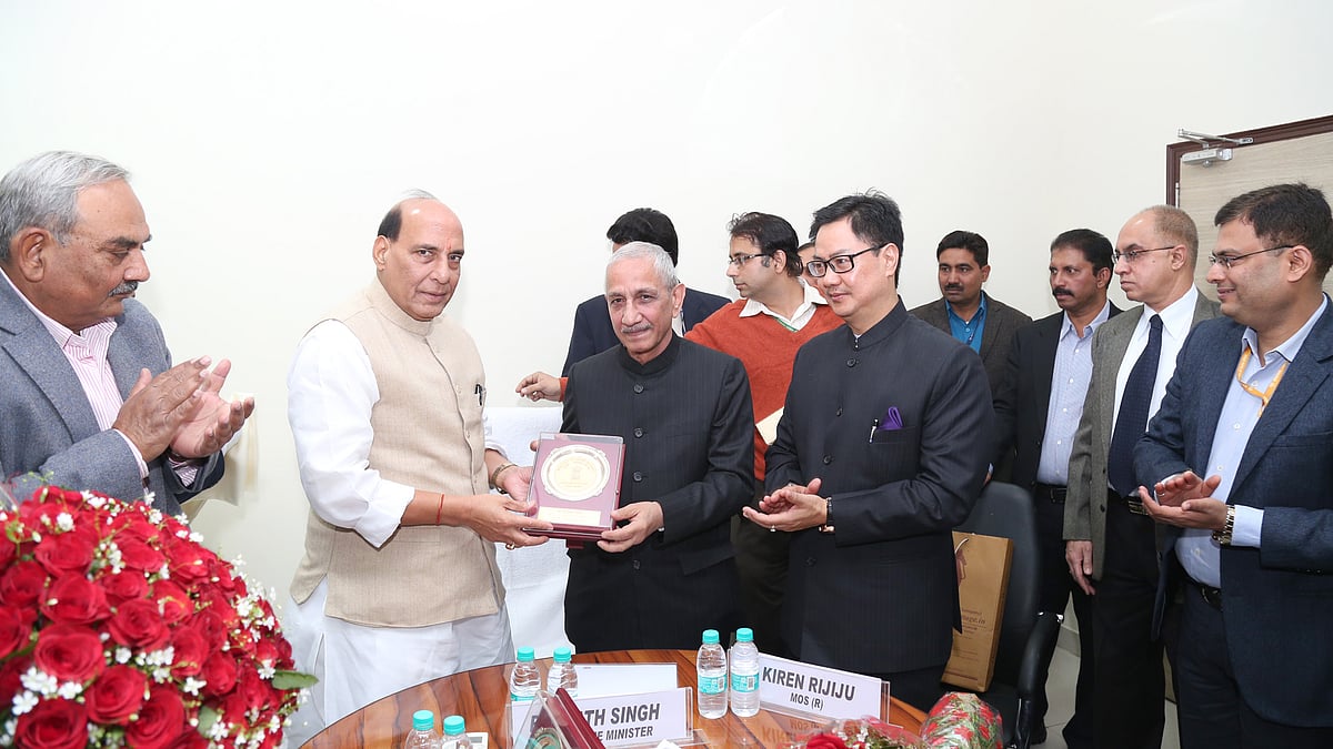 Rajnath Singh handing a memento to Dineshwar Sharma in New Delhi