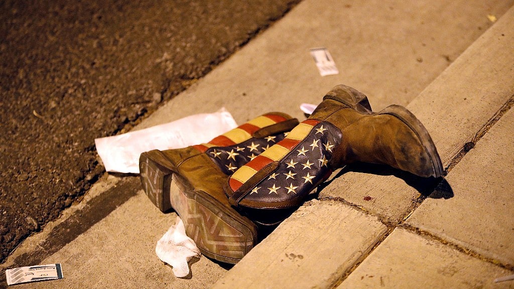 A pair of cowboy boots lying on the street outside the concert venue.