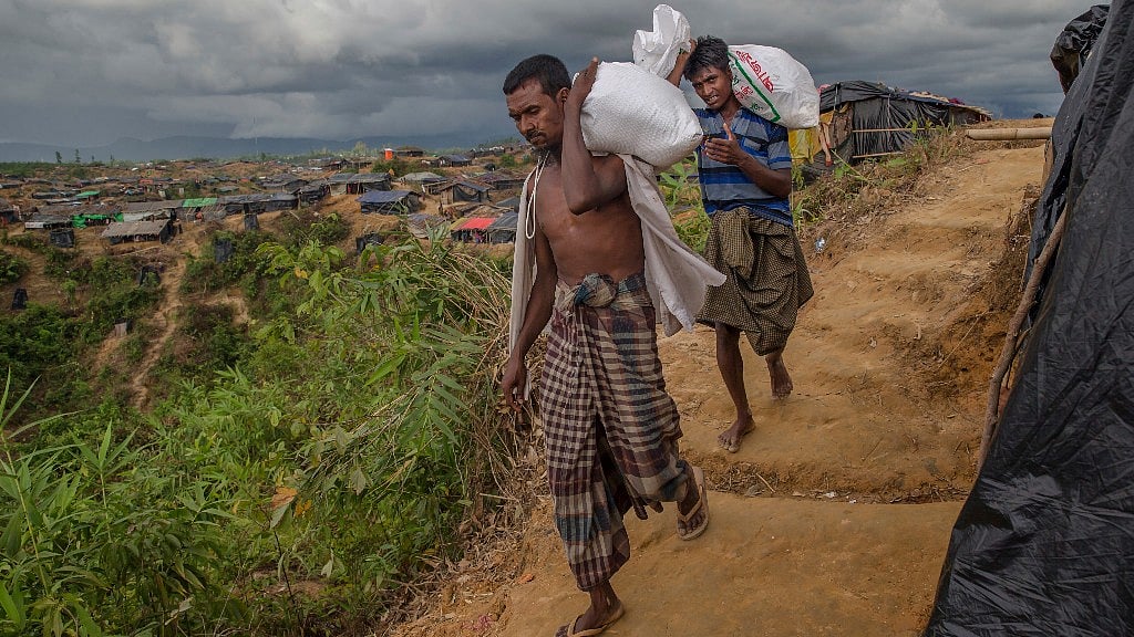Rohingya Muslims who crossed over from Myanmar into Bangladesh, walk back to their shelters after collecting aid in Taiy Khali refugee camp, in Bangladesh.