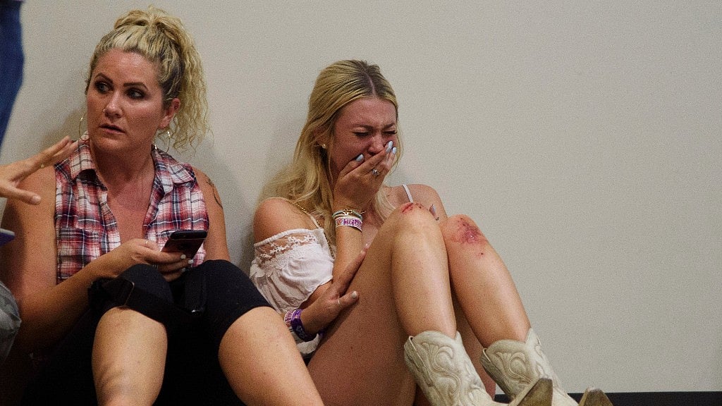 A woman cries while hiding inside the Sands Corporation plane hangar after a mass shooting in which dozens were killed at the Route 91 Harvest Festival on Sunday.