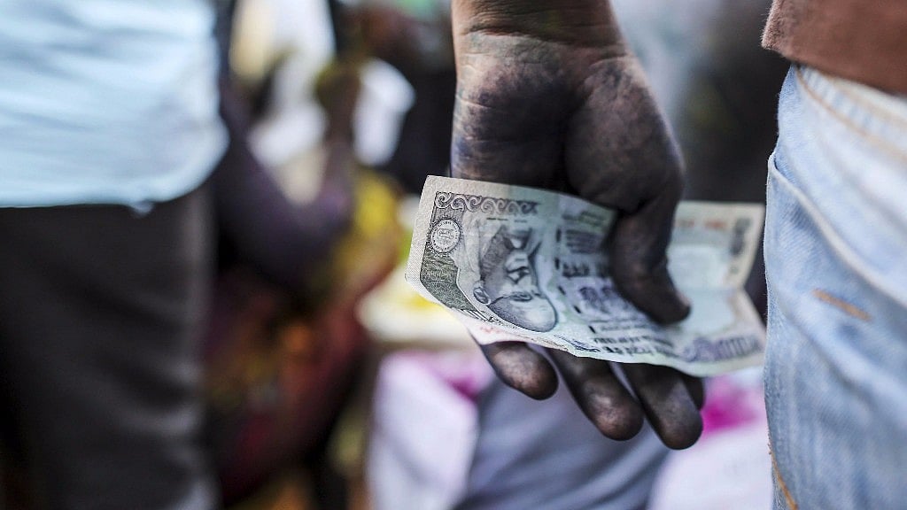 A vendor holds an Indian one hundred rupee banknote at a market stall in Mumbai on 11 March 2017. 