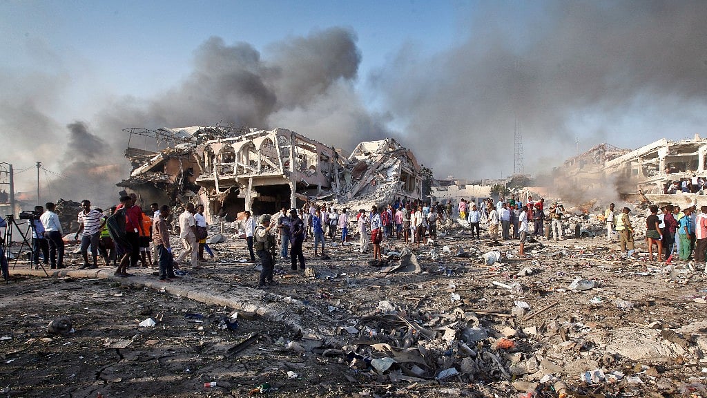 Somalis gather and search for survivors by destroyed buildings at the scene of a blast in the capital Mogadishu, Somalia.