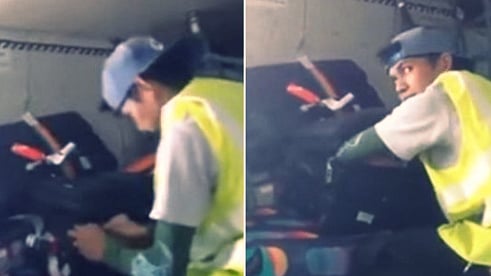 A crew member opens bags and sifts through the stuff inside them.