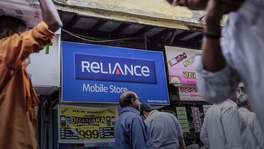 Pedestrians walk past a Reliance Communications Ltd. Mobile Store in Mumbai, India. 