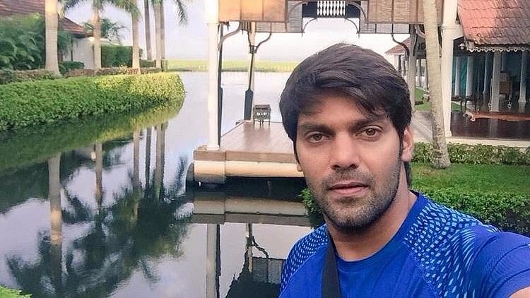 Actor Arya taking a selfie for social media.