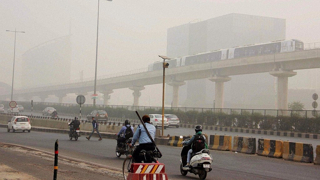 People commute in dense smog in Gurugram on Monday.