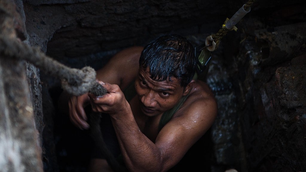 Kuldeep climbs out of the sewer in Sector 10, Ghaziabad. 